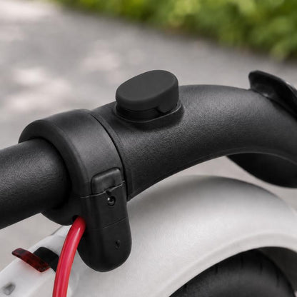 Black silicone cover for rear fender hook on an electric scooter handlebar area