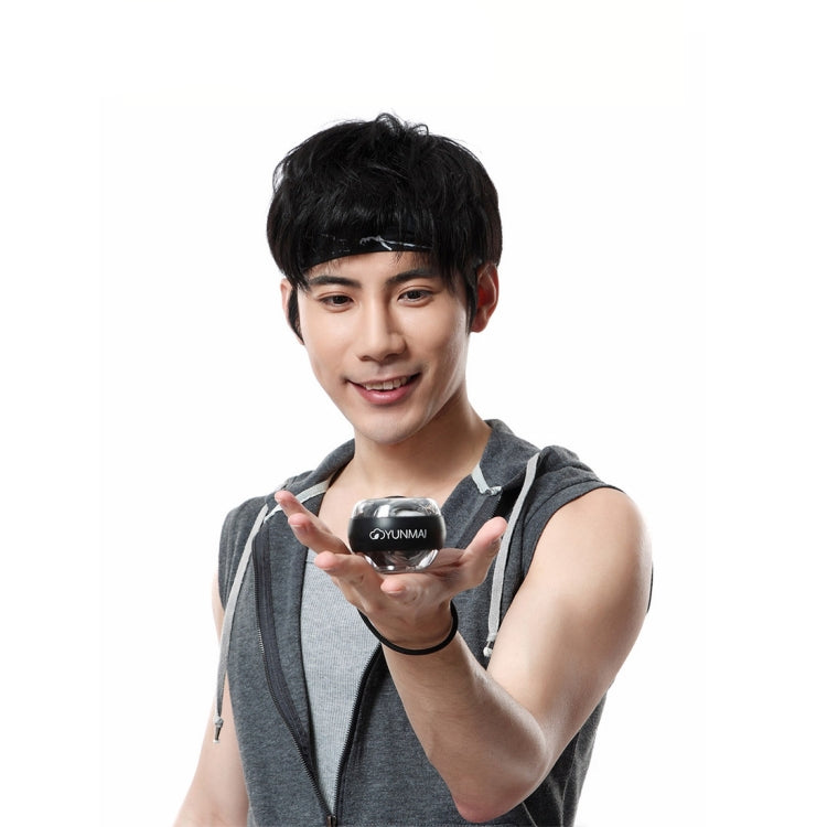 Black YUNMAI wrist gyroball spinner exerciser held in a hand with wrist strap