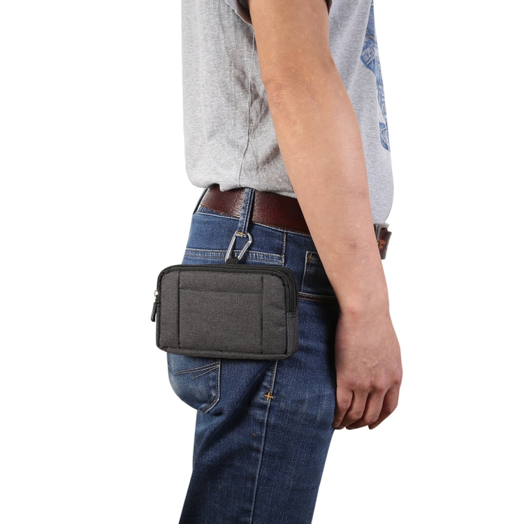 Dark gray phone waist bag worn on a belt over blue jeans with D-ring clip