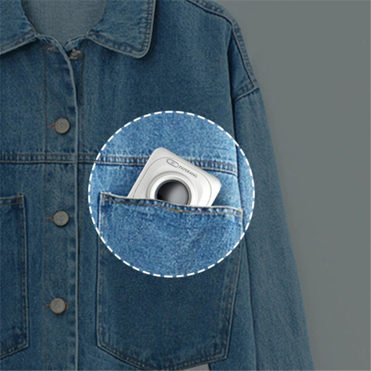 White thermal photo printer tucked in a blue denim jacket pocket