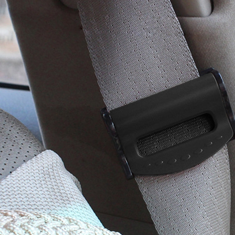 Black car seat belt adjuster clip with buckle, secured on a seat belt webbing