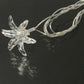 Clear star LED string light bulb attached to twisted white wire strand