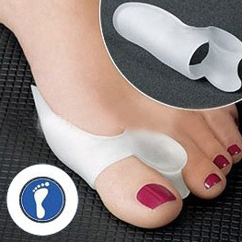 White silicone hallux valgus toe braces on feet, toe separator pads