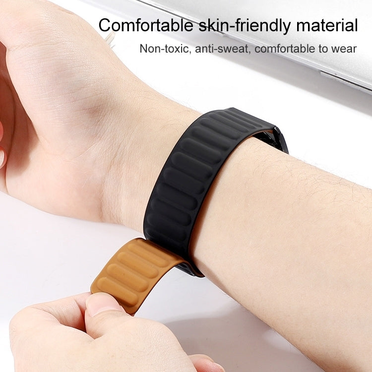 Black silicone magnetic watch band with ridged strap, shown being fastened on a wrist