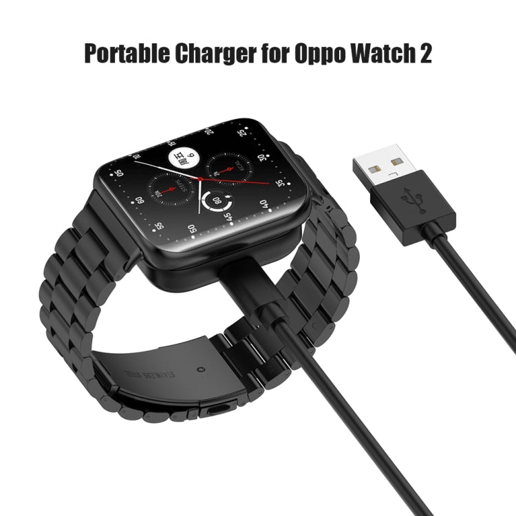 Black watch on charging dock with visible charging pins and cable