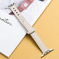 Beige microfiber leather watch strap with double buckle, metal pins and clasp, stitched edge.