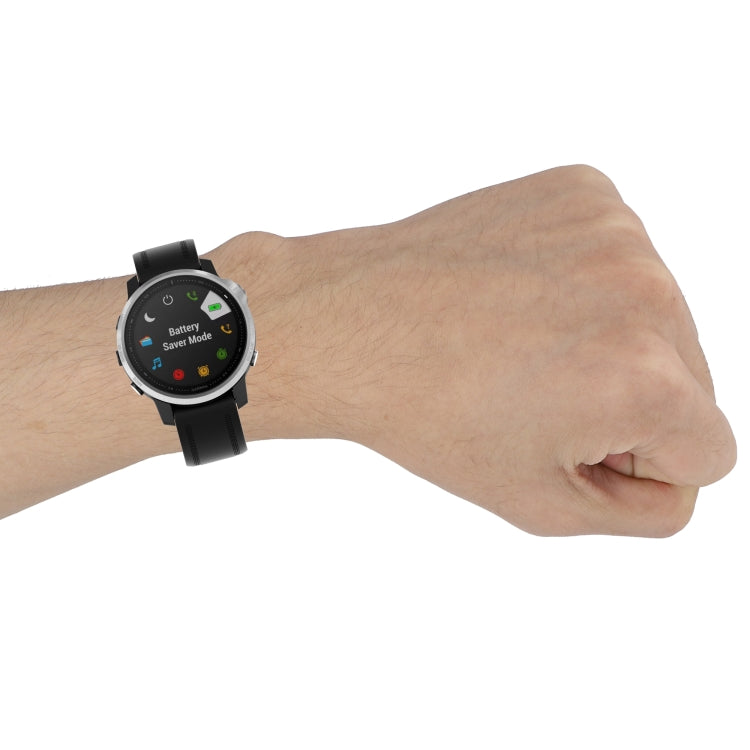 Black silicone quick-release watch strap worn on wrist, showing buckle and strap holes