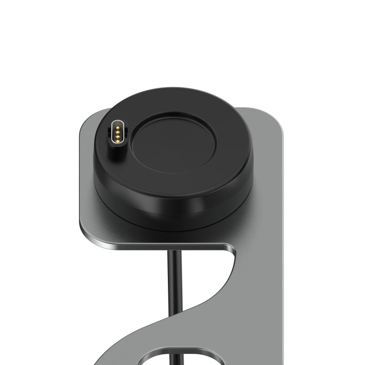 Close-up of black circular charger dock on a silver metal smartwatch stand support.