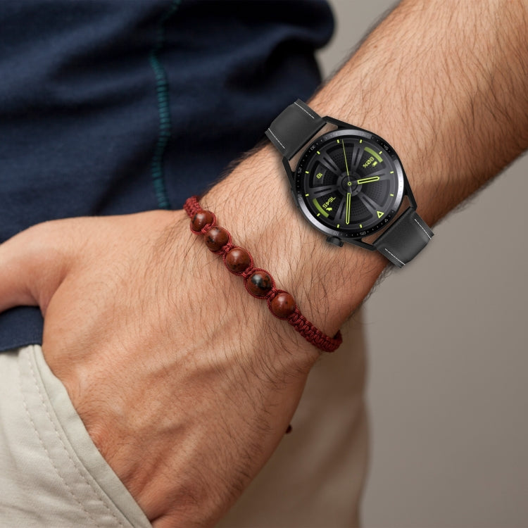 Black watch band with perforations, worn on a wrist with a smartwatch