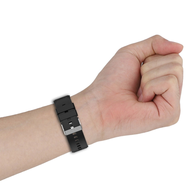 Black silicone watch band with metal connector on a wrist