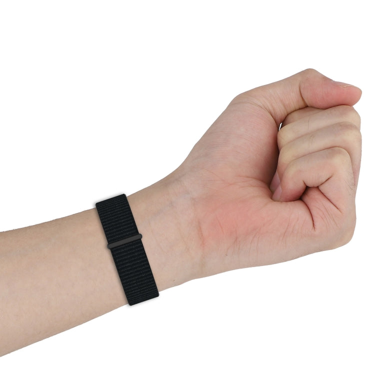 Black nylon weave watch band worn on wrist with metal clasp