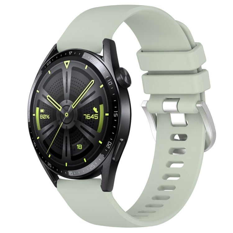 Glossy light green silicone watch band with silver buckle, punched holes, curved ends.