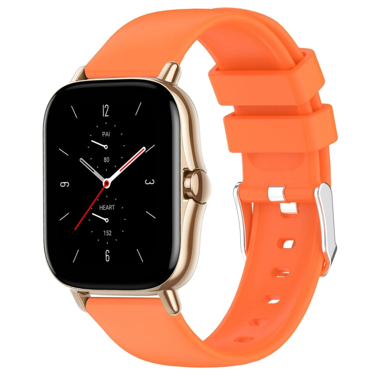 Orange silicone watch band with adjustable holes and metal clasp.