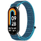 Blue patterned nylon hook-and-loop watch band with turquoise edging, shown on a fitness tracker.