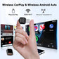 Black wireless 2-in-1 adapter dongle held in hand over car display screens