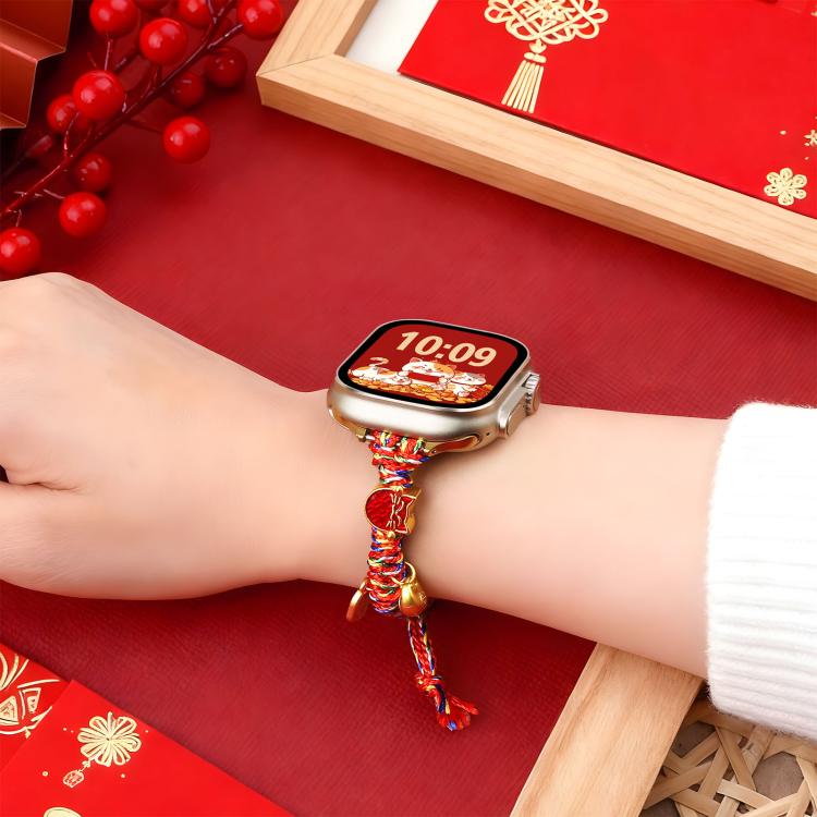Multicolor braided Apple Watch band with gold charms, worn on a wrist