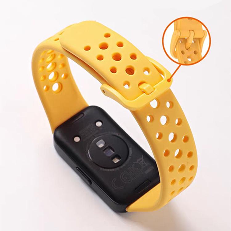 Yellow perforated silicone watch band with pin buckle, shown from the underside