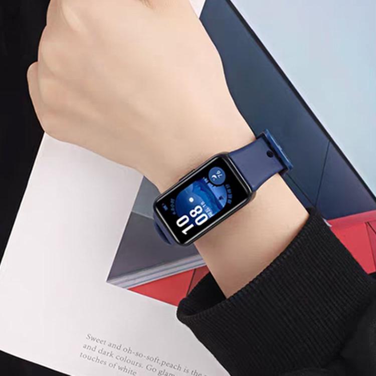 Navy silicone watch band worn on a wrist, shown with the watch face