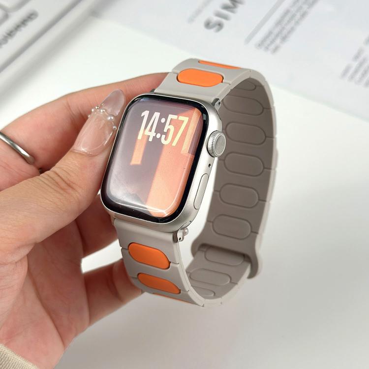 Light gray silicone magnetic watch band with orange insets, fitted on a watch.