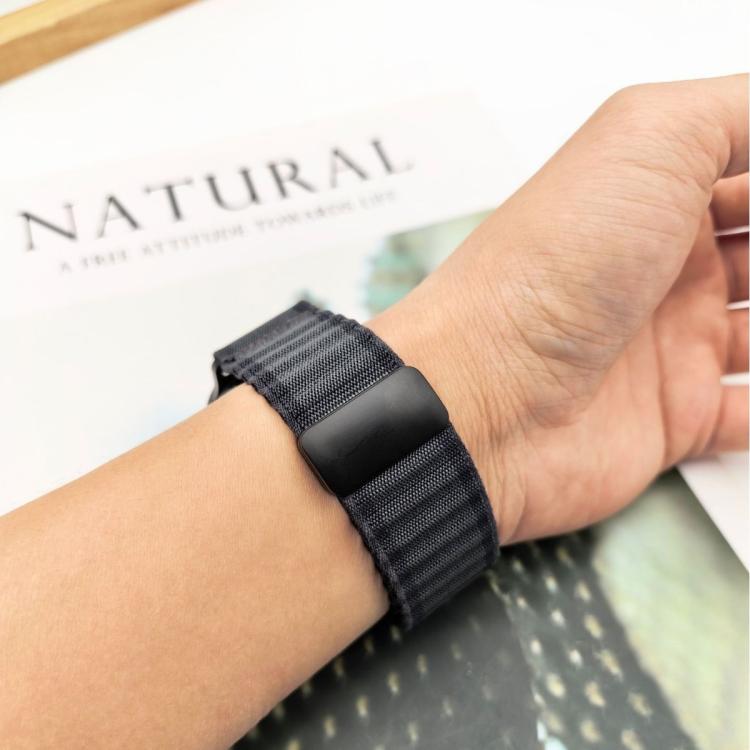 Dark gray braided nylon watch band with magnetic buckle worn on a wrist