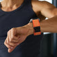 Orange ribbed nylon watch band with black buckle fitted to a smartwatch on a wrist