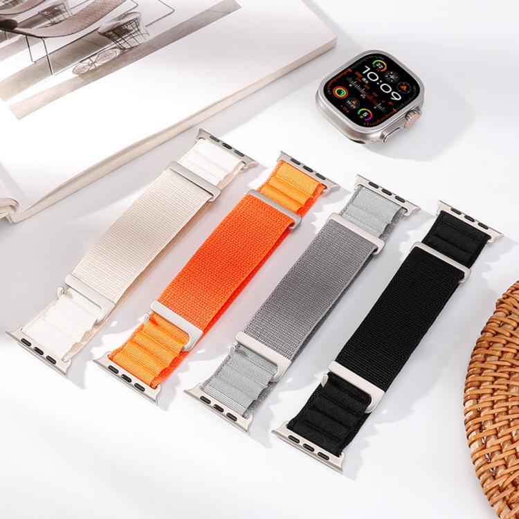Four nylon Apple Watch bands in cream, orange, gray, and black