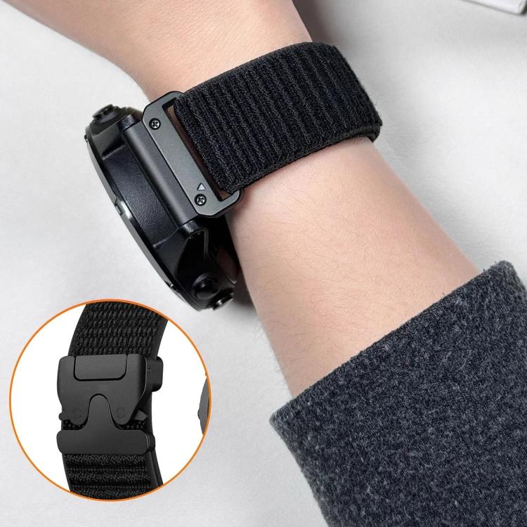 Black woven nylon watch band with metal tip and parachute-style buckle, worn on wrist
