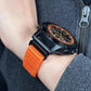 Orange woven nylon watch band with metal connector, shown on wrist with watch