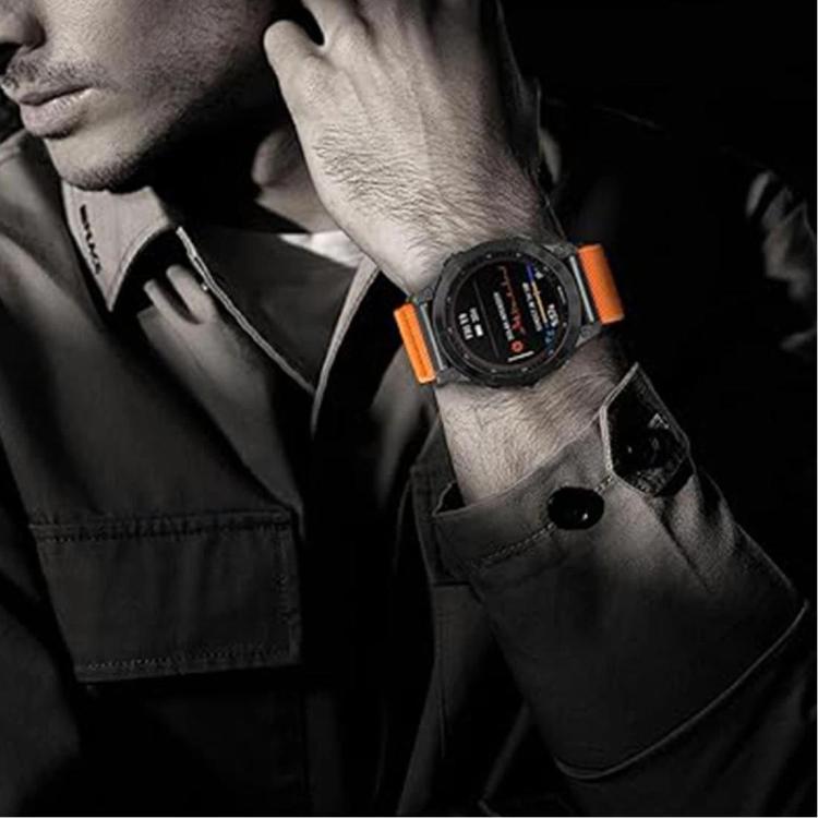 Orange stretch nylon watch band with black smartwatch, worn on a wrist.