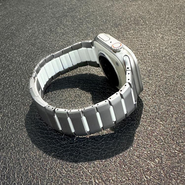 Silver stainless steel watch band with curved links, attached to a watch