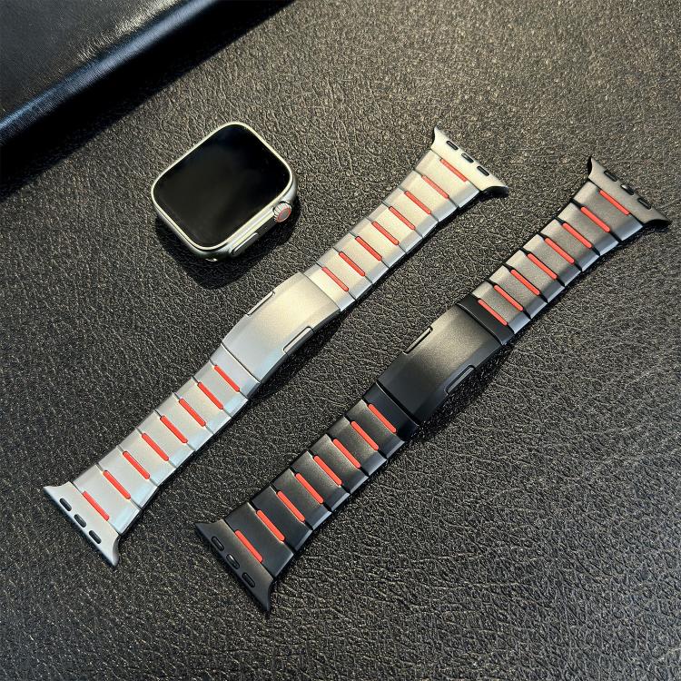 Silver and black stainless steel watch bands with red accents beside a watch