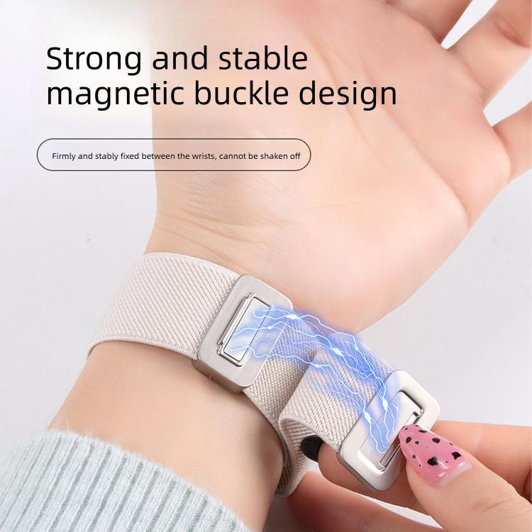 Light cream nylon watch band fastened around a wrist with its magnetic buckle