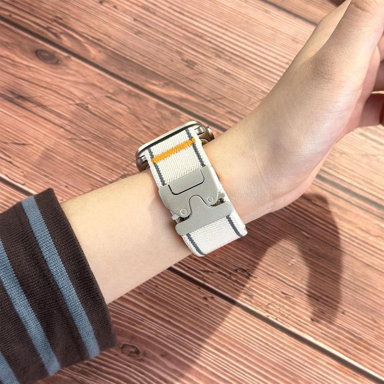 Starlight woven nylon Apple Watch band worn on the wrist, with orange accent and buckle