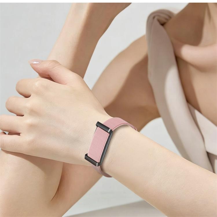 W01 screenless smart bracelet with a pink woven band and black clasp, worn on the wrist