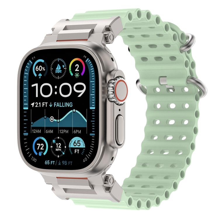 Pale green perforated silicone watch band with metal connectors on a compatible watch.