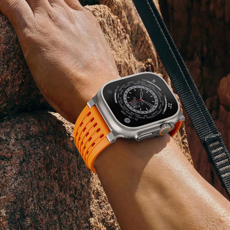 Orange vented silicone Apple Watch band worn on the wrist