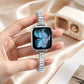 Apple Watch with silver crystal-set bracelet band, held in hand