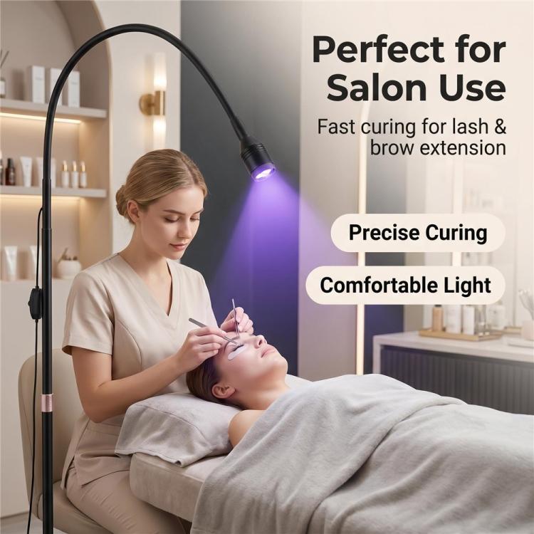 Black floor UV LED curing lamp with glowing bulb near client during lash treatment