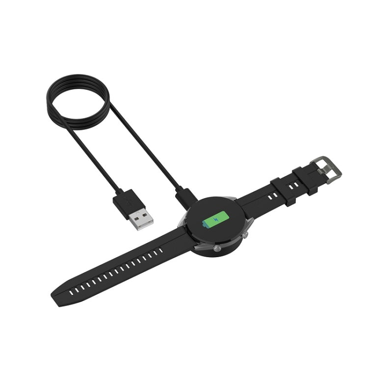 Smartwatch on wrist charging with black USB magnetic cable and dock