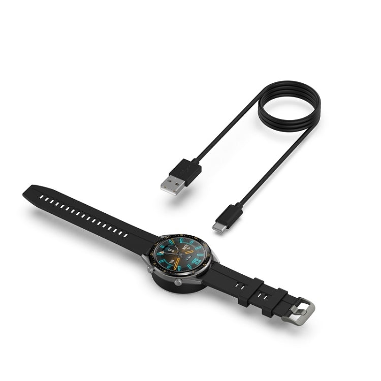 Smartwatch with black strap charging using black USB magnetic cable