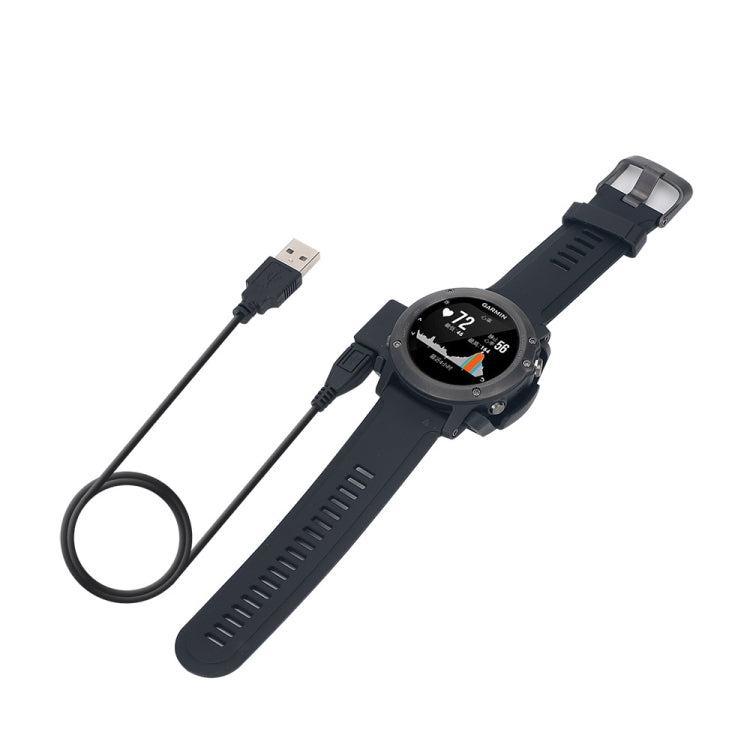 Garmin watch on charging dock with connected USB-A cable and black power cord