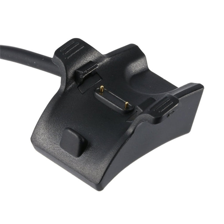 Black charging cradle with gold contact pins and cable loop