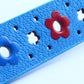 Blue PU leather belt close-up with red flower and star-like cutout pattern
