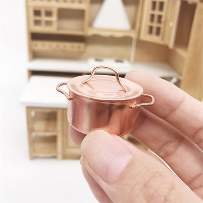 Miniature copper pot with lid, two side handles, held in hand