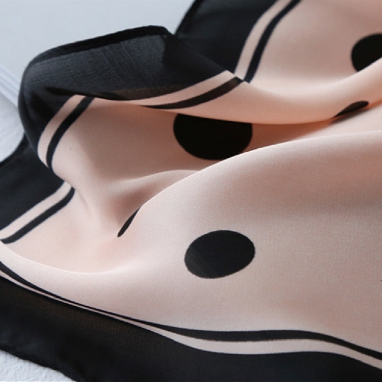Beige silk scarf close-up with black dots and black curved stripe lines