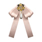 Champagne satin bow brooch with gold and pearl cross centerpiece