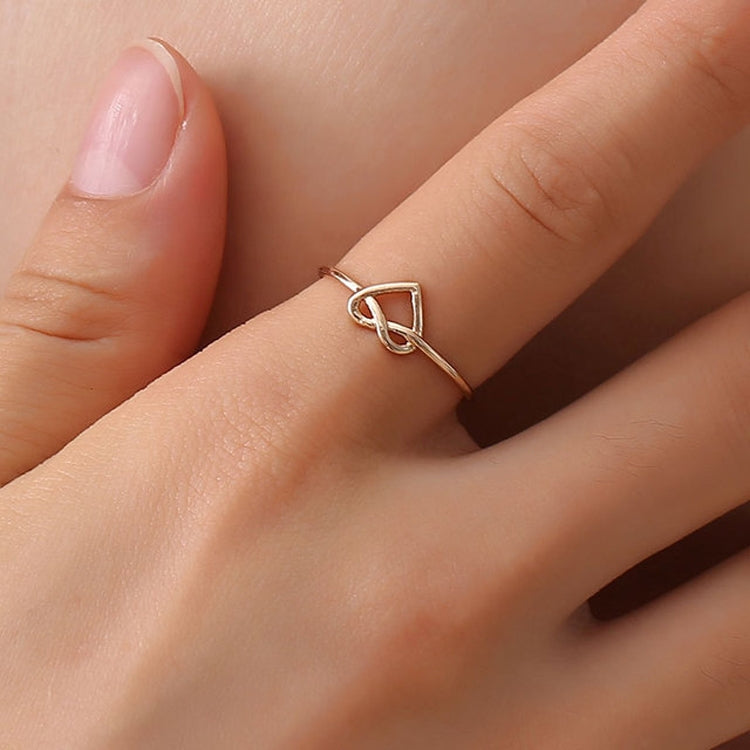 Gold adjustable heart hollow ring on finger, open band with heart cutout