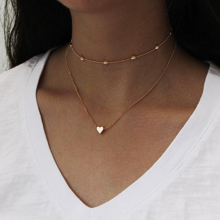 Gold multi-layer heart clavicle necklace worn on neckline with two hearts