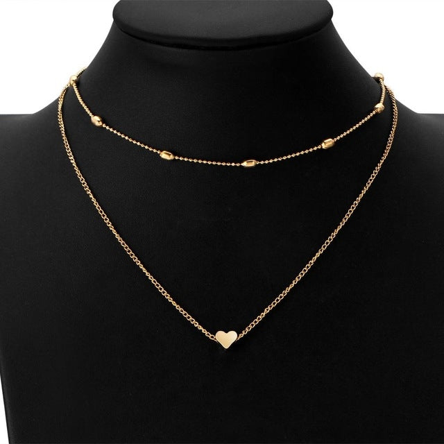 Gold two-chain heart clavicle necklace with small center heart pendant