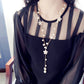 Long pearl necklace with five-petal flower charms and dangling pearl drops
